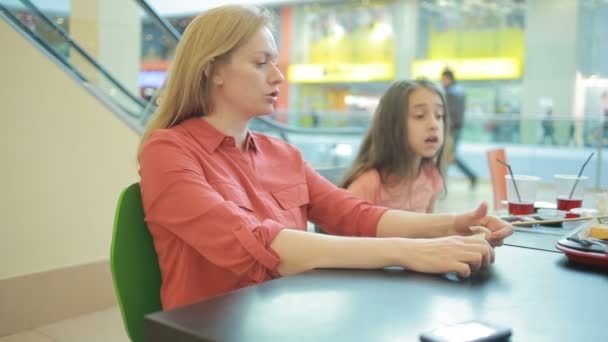 Una mujer gorda come una magdalena en un café y bebe café. — Vídeos de Stock