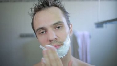 adam banyoda jilet ile onun sakalı tıraş