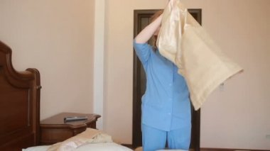 Hizmetçi yatak odasında temizlik yapıyor