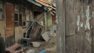 Bir genç eski terk edilmiş ev, sokak görünümü bir etrafında dolaşır.