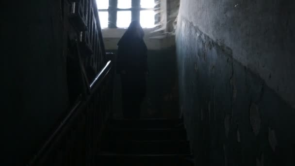 Egy férfi egy fekete kapucnis szörnyű régi házban egy cobweb kapucnival. — Stock videók