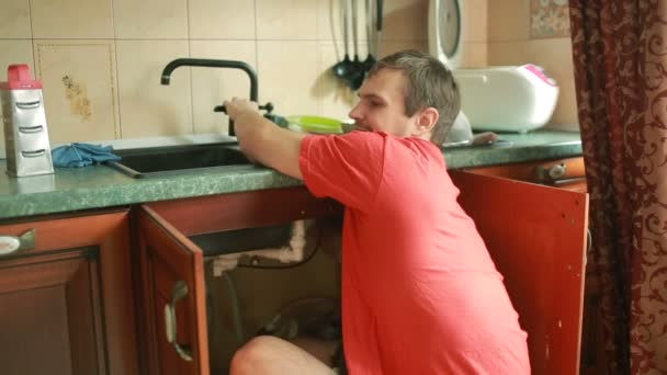 Ingeniería sanitaria reparación de fugas de agua. hombre que fija un grifo en la cocina — Vídeos de Stock