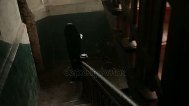 Siyah kapüşonlu bir erkekte bir mahallede bir örümcek ağı ile korkunç bir eski ev ile.