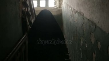 Siyah kapüşonlu bir erkekte bir mahallede bir örümcek ağı ile korkunç bir eski ev ile.