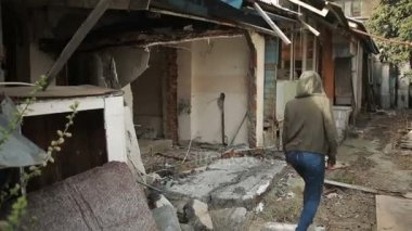 Bir genç eski terk edilmiş ev, sokak görünümü bir etrafında dolaşır.