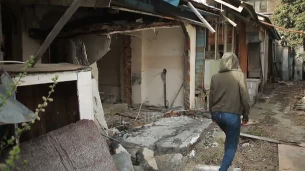 Nastolatek wędruje stary opuszczony dom, widok z ulicy. — Wideo stockowe