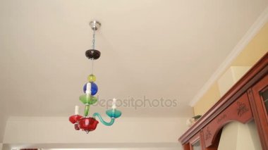 Yakışıklı erkek gömlek bir ampul bir kristal lamba için değiştirir.