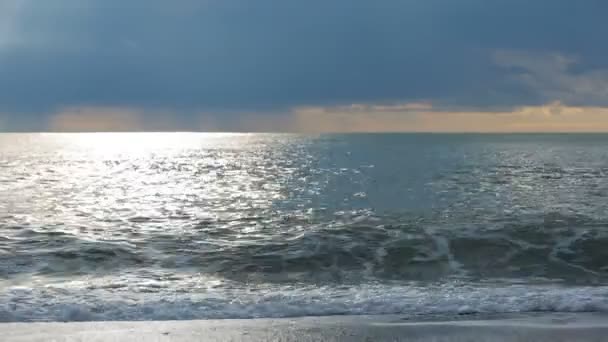 L'alésage des marées. Coucher de soleil en mer, les rayons du soleil traversent les nuages — Video