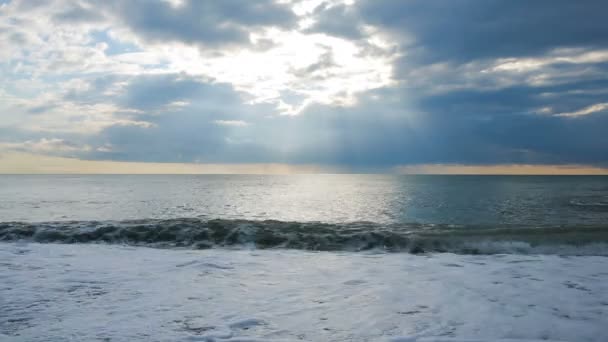 Приливная волна. Закат в море, лучи солнца пробираются сквозь облака — стоковое видео