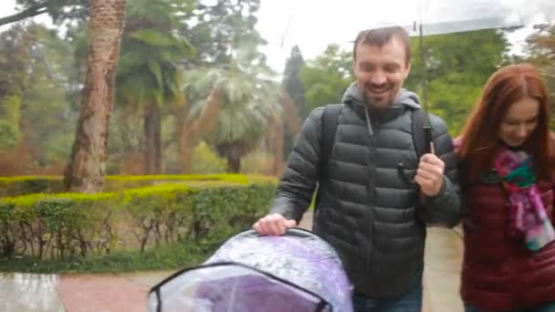 Mamãe e papai, brincando com seu filho, sentados em um carrinho: caminhe no parque — Vídeo de Stock