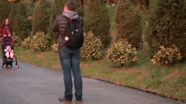 Pappa en mamma, spelen met hun kind, zittend in een wandelwagen: lopen in het park — Stockvideo