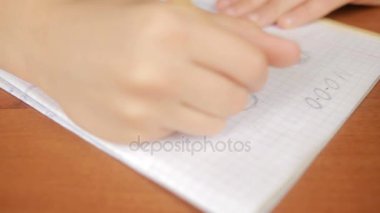 Bir genç basit bir kalem bir defterde çizer. Yakın çekim