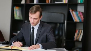 Bir bilgisayar ve ofis belgeleri çalışma çekici iş adamı