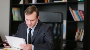 Bir bilgisayar ve ofis belgeleri çalışma çekici iş adamı