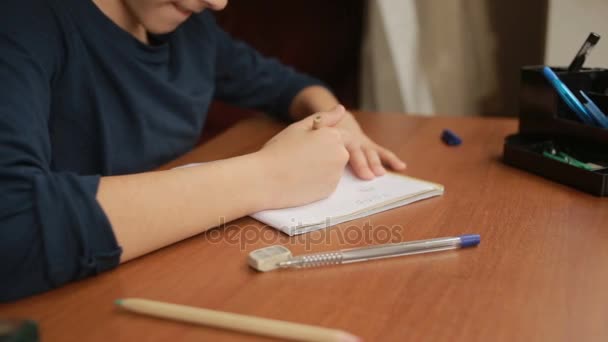 Ένας έφηβος τραβάει ένα απλό μολύβι σε ένα σημειωματάριο. Γκρο πλαν — Αρχείο Βίντεο