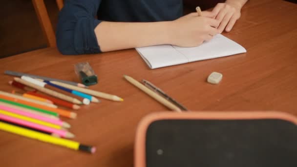 Un adolescent dessine un simple crayon dans un carnet. Gros plan — Video