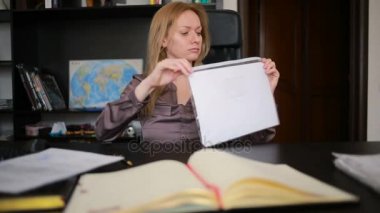 Bir bilgisayar ve Office belgeleri ile çalışan çekici kadın