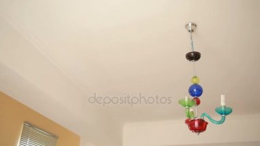 Yakışıklı erkek gömlek bir ampul bir kristal lamba için değiştirir.