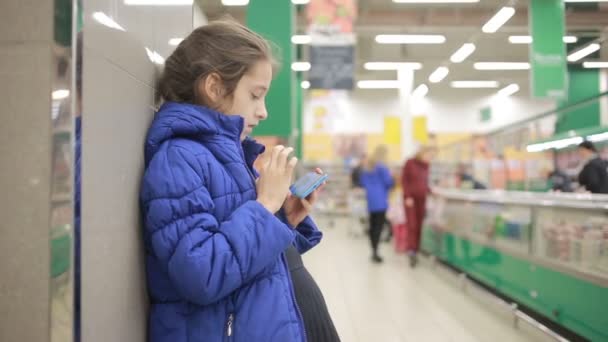 De dochter en haar moeder zijn winkelen bij de supermarkt. Weinig assistent Meesteres — Stockvideo