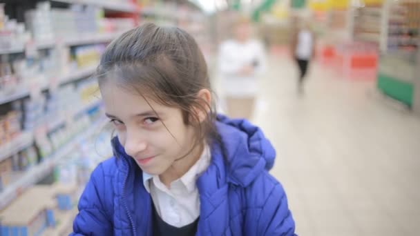 Tochter und Mutter kaufen im Supermarkt ein. kleine Assistentin — Stockvideo