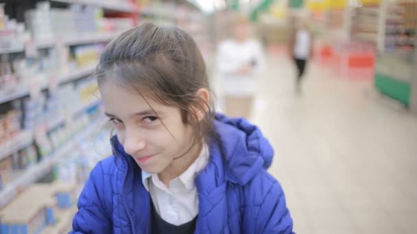 A filha e a mãe estão a fazer compras no supermercado. Pouco assistente amante — Vídeo de Stock