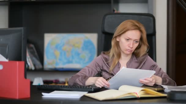 Attraente donna d'affari che lavora con un computer e documenti in ufficio — Video Stock