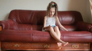 Küçük kız selfie smartphone cep telefonu ile evde kanepede yapıyor