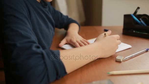 Een tiener wordt een eenvoudige potlood getekend in een notebook. Close-up — Stockvideo