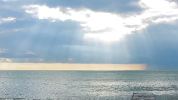 Tidvatten bore. Solnedgången vid havet, solen gör sin väg genom molnen strålar — Stockvideo