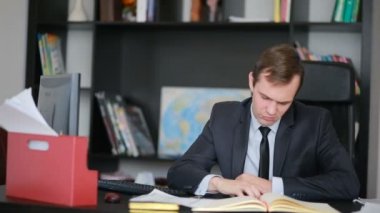 Ofis Yöneticisi çalışmalarını yorgun masada oturur