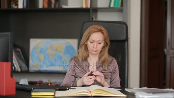 Mulher de negócios atraente que trabalha com um computador e documentos no escritório — Vídeo de Stock