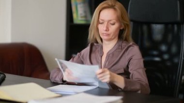 Bir bilgisayar ve Office belgeleri ile çalışan çekici kadın