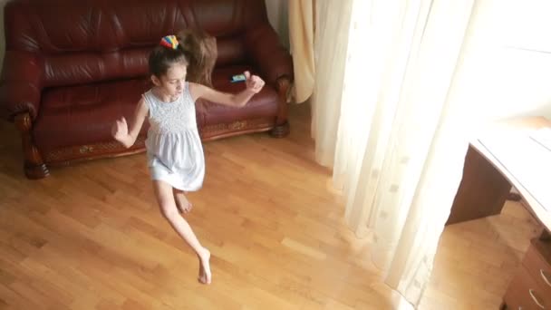 Маленька мила дівчинка танцює і обманює вдома — стокове відео