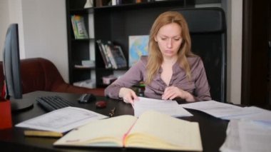 Bir bilgisayar ve Office belgeleri ile çalışan çekici kadın