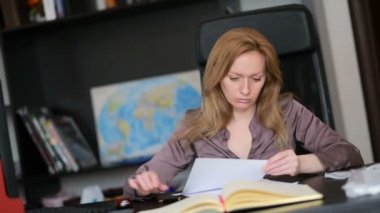 Bir bilgisayar ve Office belgeleri ile çalışan çekici kadın