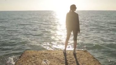 Deniz kenarında bir iskelede duran, mesafe içine arayan kadın