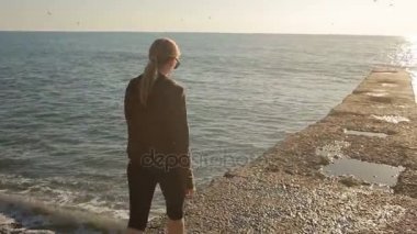 Deniz kenarında bir iskelede duran, mesafe içine arayan kadın