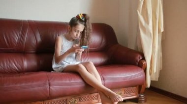 Küçük kız selfie smartphone cep telefonu ile evde kanepede yapıyor