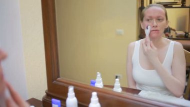 Mezoterapi evde. Kız mesorollerom aynanın önünde ev çehresini işleme