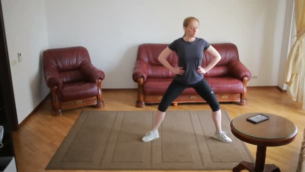 Ev hanımı kadın fitness egzersizleri ilk kez, tablet ve Tv bakarak mı, zor ve yabancı, çok yoruldu. — Stok video