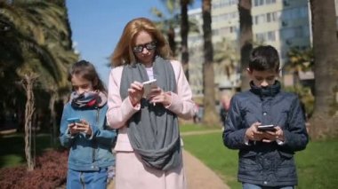 Çocuklu bir kadın. Anne ve çocuk sokak yürüyor, herkes onların telefon ile meşgul