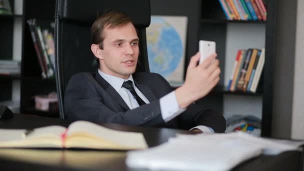 Attractive business man talking on the phone doing selfie at the office — Stock Video