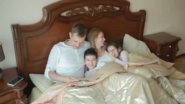 Famiglia felice a letto leggere un libro ad alta voce a casa — Video Stock