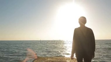 Deniz kenarında bir iskelede duran, mesafe içine arayan kadın