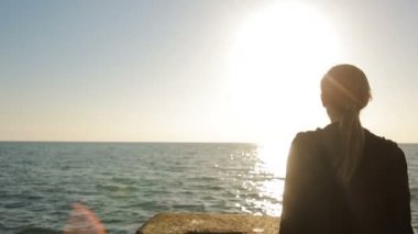 Deniz kenarında bir iskelede duran, mesafe içine arayan kadın