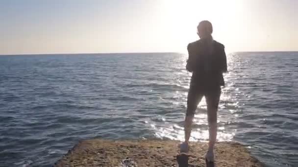 Vrouw staande op een pier door de zee, op zoek naar de afstand — Stockvideo