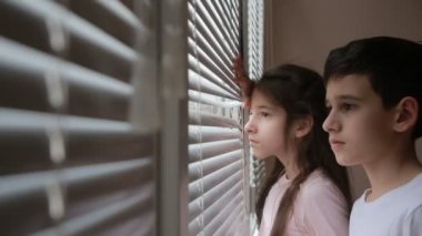 Küçük kız ve çocuk, kardeşi ve güneşlikler pencereden sokaktan kardeş, İki Yataklı bakar