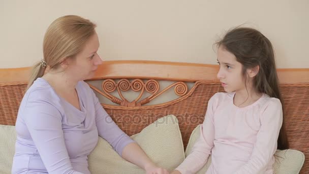 Mamá e hija hablan de corazón a corazón en casa en un sofá de mimbre — Vídeos de Stock