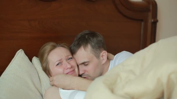 Treurige vrouw wordt getroost door haar partner in bed — Stockvideo