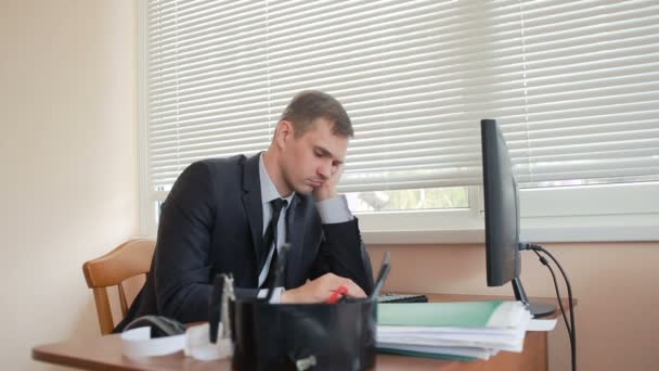 Manažer v kanceláři sedí u stolu, unaveni z práce — Stock video